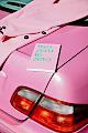 A pink planner and a pink blazer on a pink Mercedes Benz car