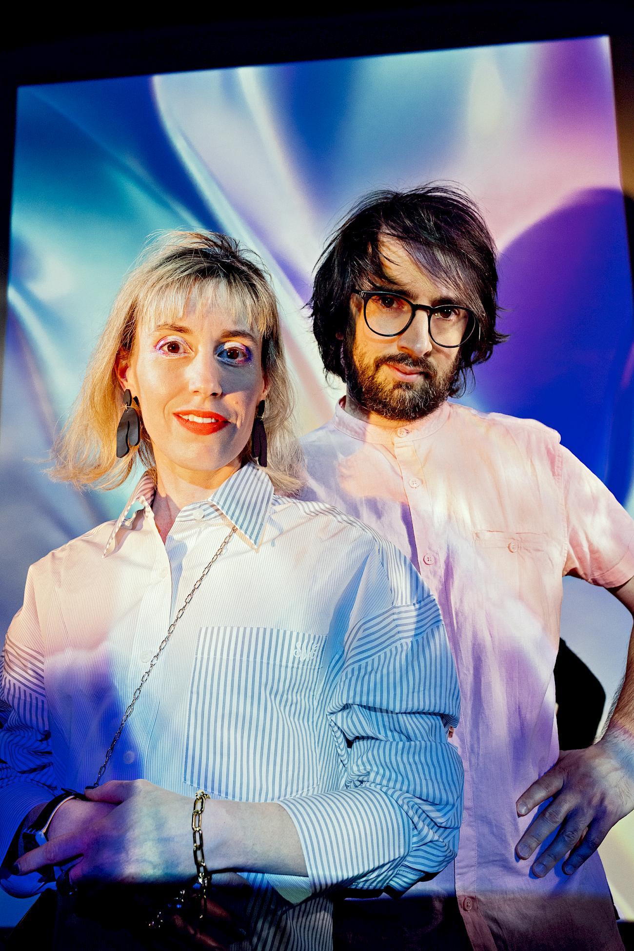 Maya and Daniele in front of colorful light projections