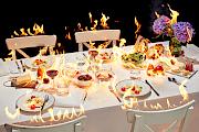 A still life of a burning table with food and drinks