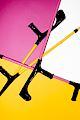 Pink and bright yellow crutches on a pink and yellow background