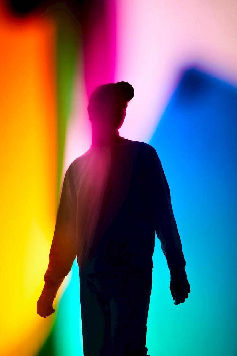 Silhouette of Jan against a colourful light play. Portrait for NZZ am Sonntag