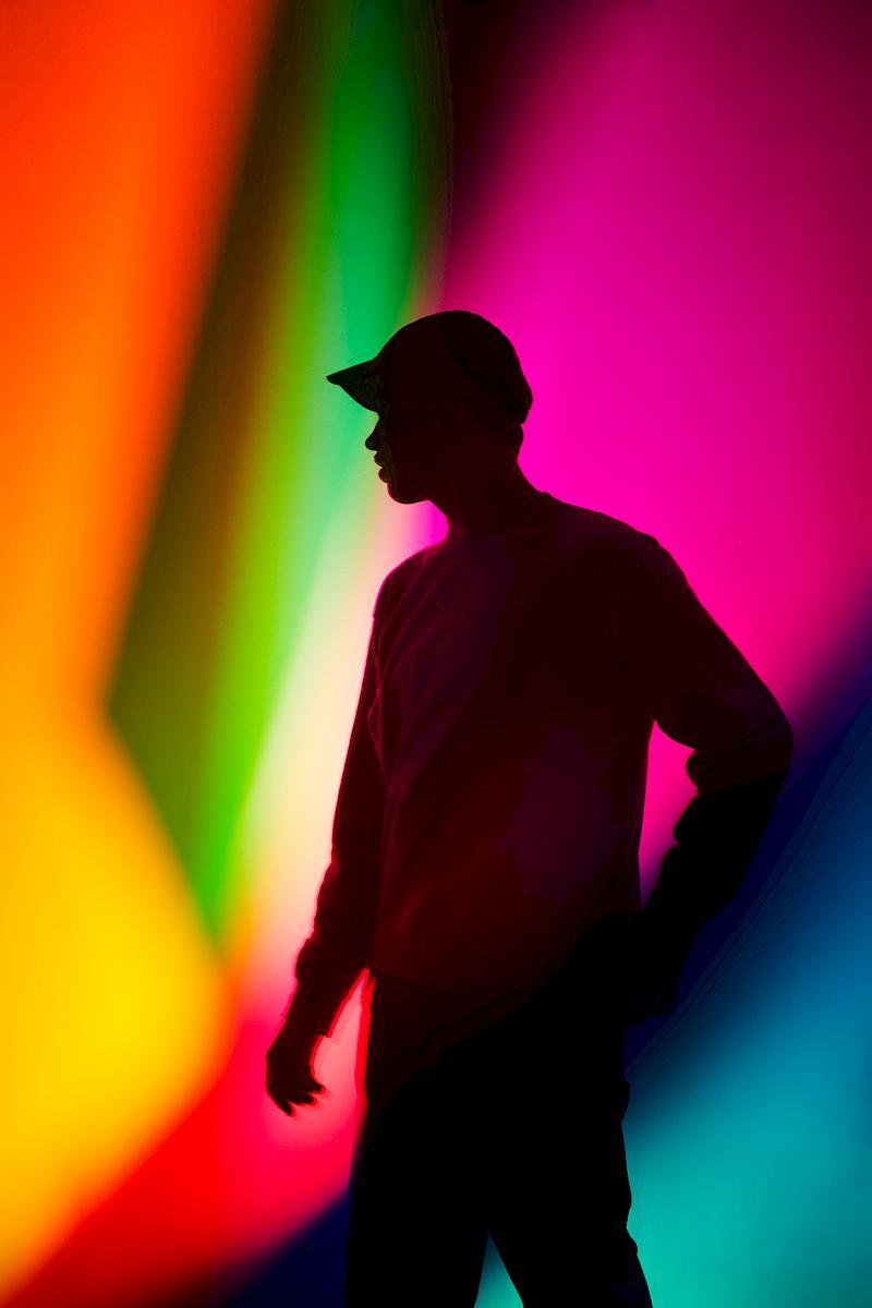 Silhouette of Jan against a colourful light play. Portrait for NZZ am Sonntag