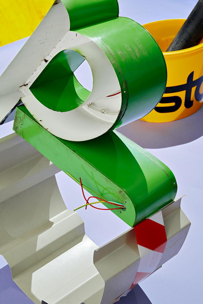 Still life of an old green neon sign letter and other construction materials