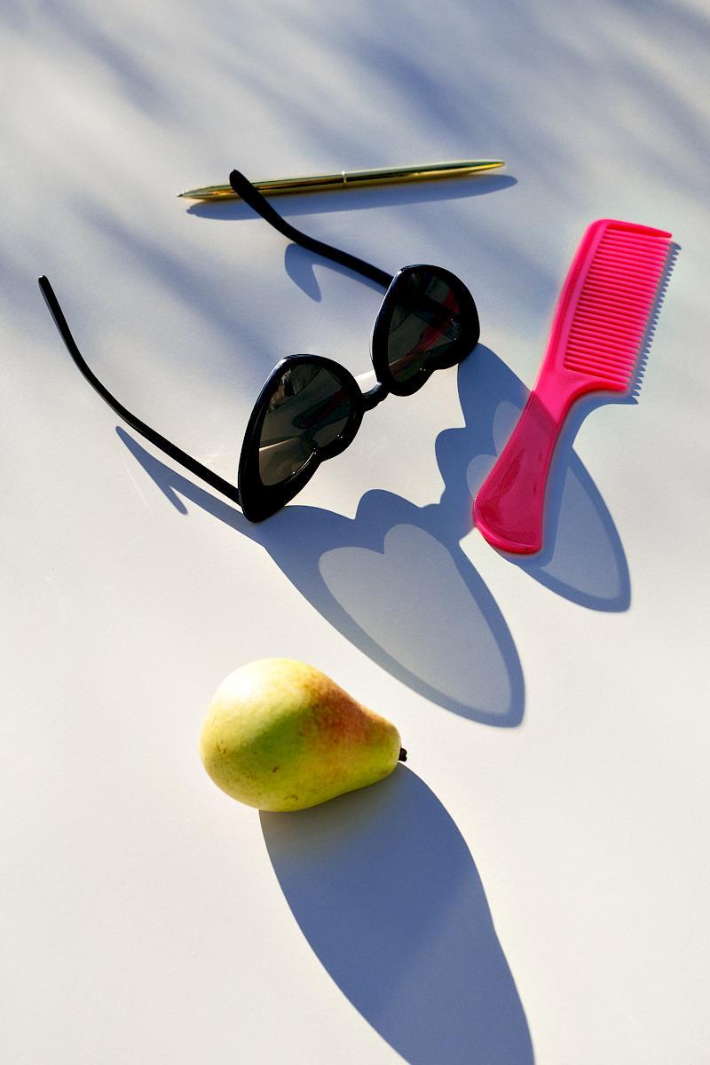 A pair of Yves Saint Laurent new wave 181 Leulou heart sunglasses with a pear, a comb on a ball pen