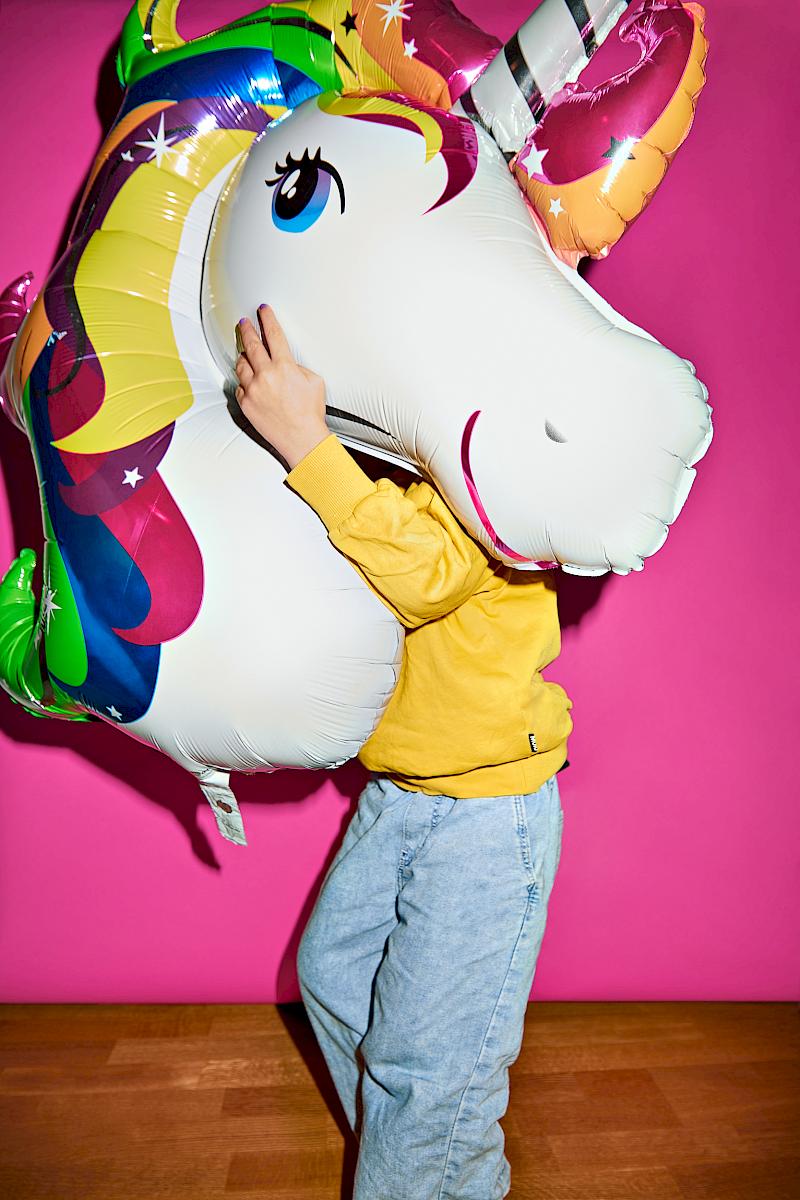 A boy holding a magic unicorn foil balloon