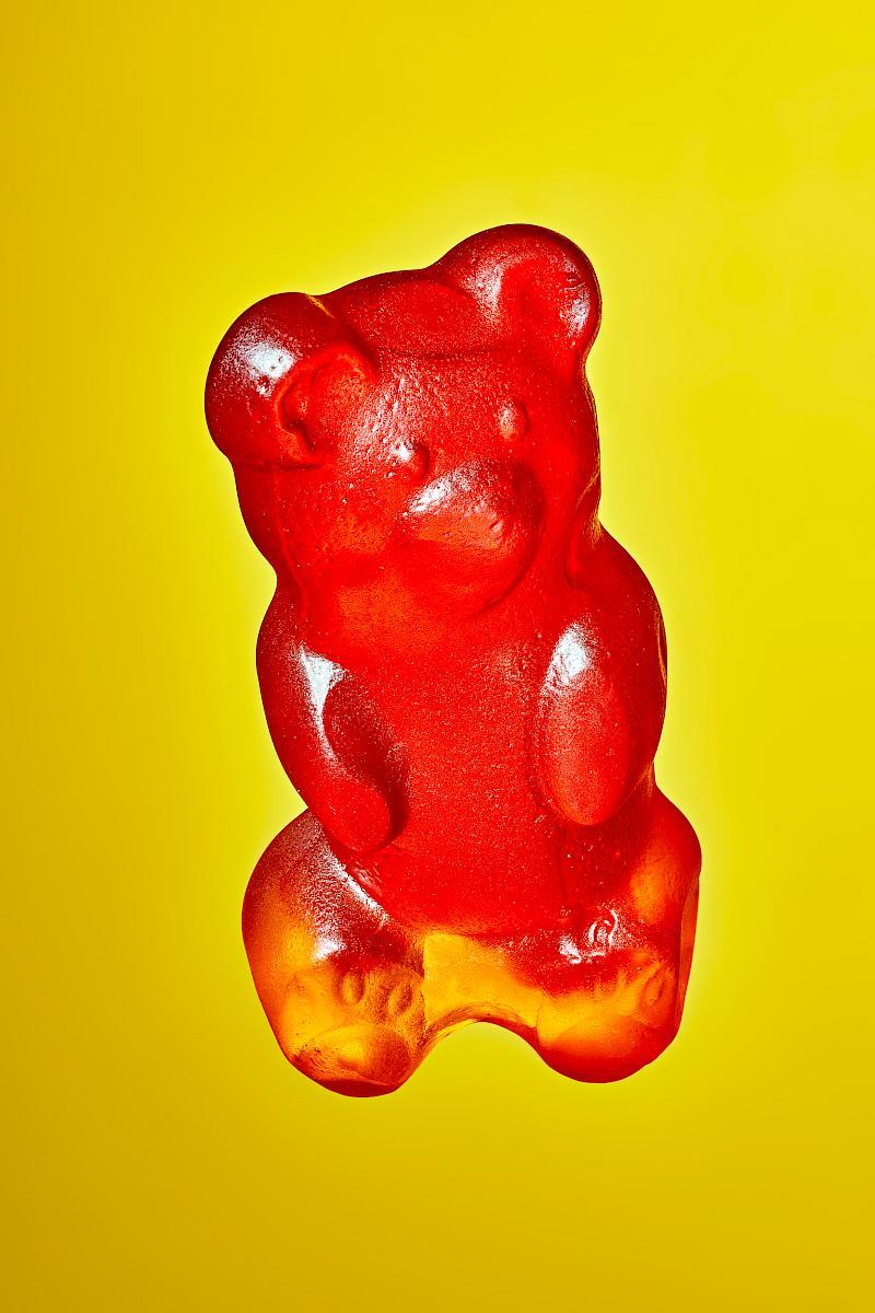 A Red Mega Gummy Bear on a Yellow Background