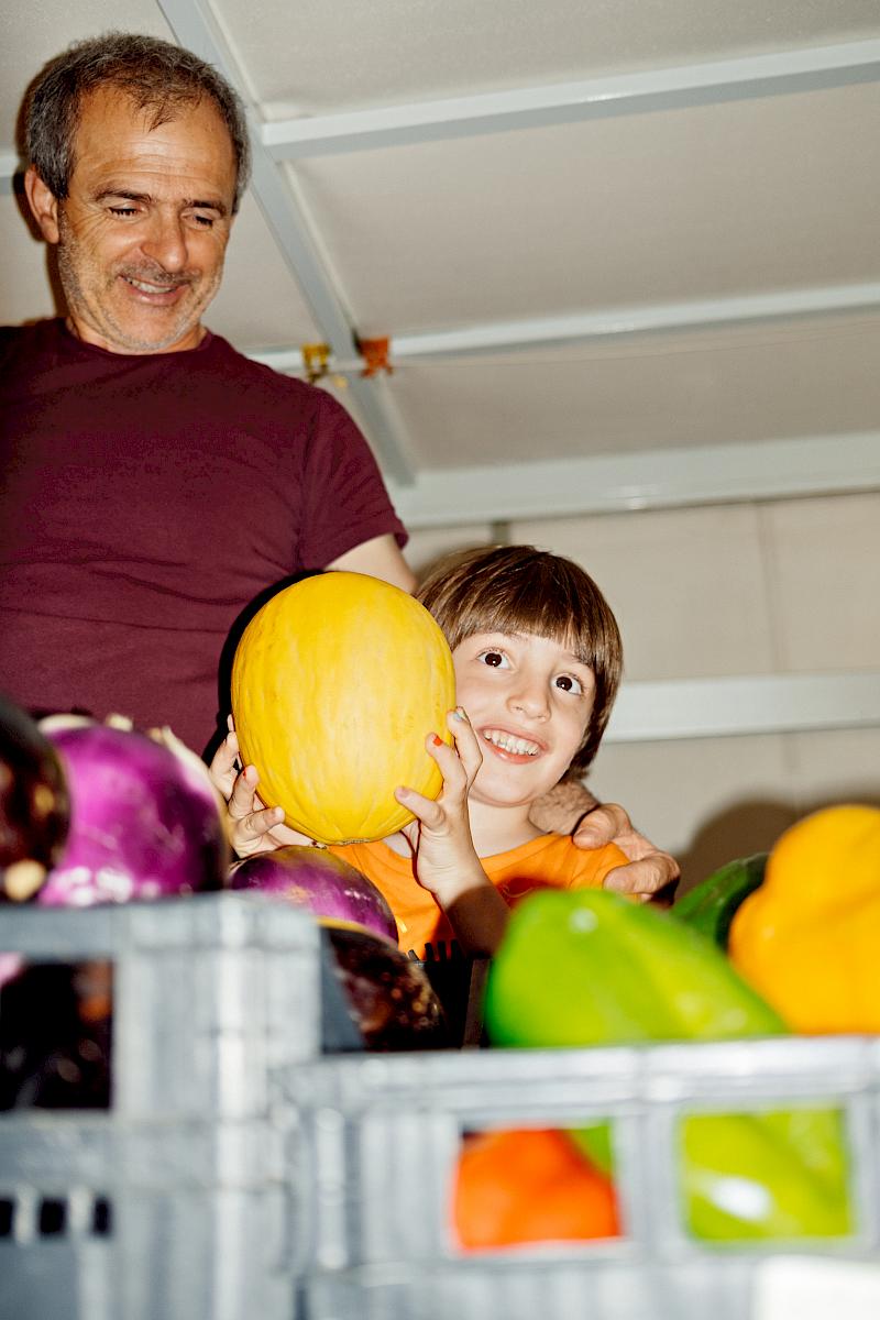 Adult and child standing in a Farmers' market stand