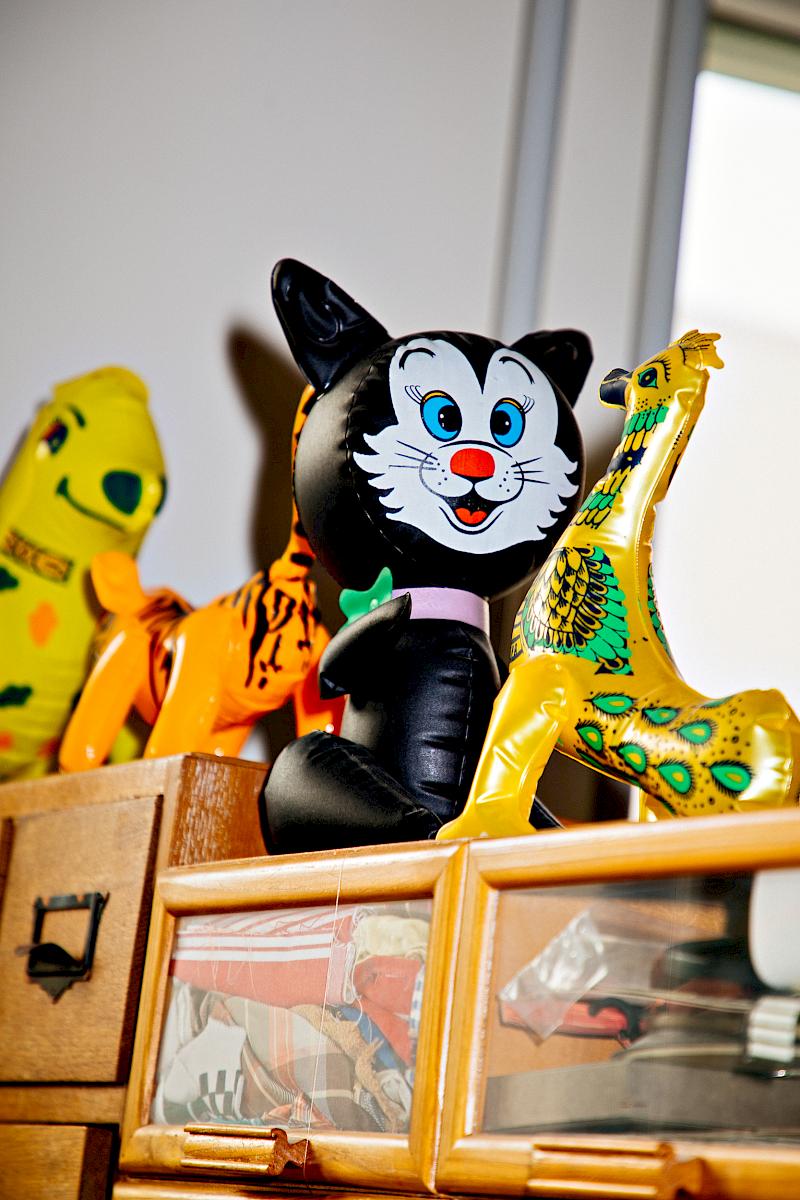 Vintage inflatable toys, displayed on wooden cabinets inside the studio